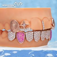 Grillz ouverts personnalisés plaqués or rose et argent, avec détails empreinte digitale, accents de pierres précieuses colorées, pierres latérales en opale rose, et partie inférieure entièrement pavée de pierres.