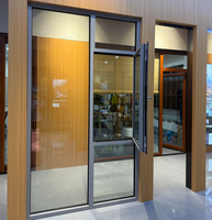 Porte moderne en verre trempé avec cadre en alliage d'aluminium, à ouverture battante et étanche, idéale pour les balcons ou les maisons