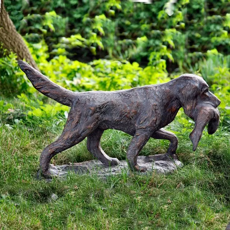Le chien en laiton en métal porte le poisson sculpture bronze moulé statues de chien grandeur nature pour la décoration de jardin