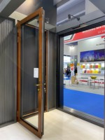 Una puerta abatible de madera maciza francesa moderna con un marco de aleación de aluminio y una puerta de vidrio exterior, delineando un ambiente cálido en el hogar