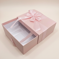 Stabile Geschenkbox im Schubladenstil mit Schleifenband, handgefertigt von einem Architekturstudio, raffiniertes rosa Etui für Bekleidung.