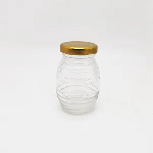 Venta al por mayor diferentes tamaños100ml 180ml 250ml 380Ml 500ml 730ml colmena/panal en forma de tarro de miel de vidrio barato