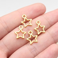 Colgante de aleación con contorno de estrella hueca de 14x11mm y 1 bucle en tono dorado para collar de capas celestiales