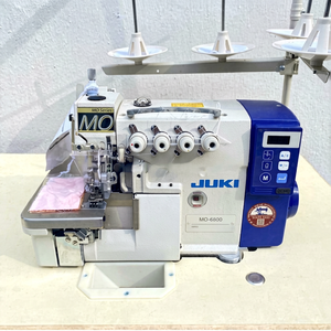Machine à coudre industrielle d'occasion JUKI MO-6814D à entraînement direct, surjeteuse 4 fils avec coupe-fil automatique - Product Image 1