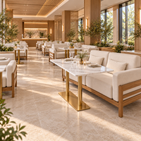 Ensemble de canapés de restaurant de style côtier moderne, chaises et tables, canapé en chêne clair avec coussins crème et table en marbre blanc avec pieds dorés