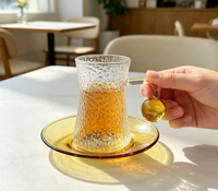 Ensemble de tasses à café en verre borosilicate martelé, forme sablier texturée, avec poignée boule ambrée, capacité 120 ml, et soucoupe à thé