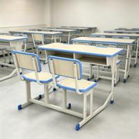 Ensemble bureau et chaise double connectés réglables, structure en acier robuste, mobilier d'étude moderne pour étudiants, idéal pour les salles de classe.