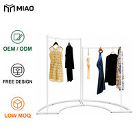 Porte-vêtements en îlot avec support au sol en forme d'arc pour l'affichage central en magasin de vêtements et la présentation de la mode