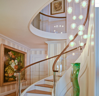 Transformez votre espace de vie avec une escalier en arc moderne doté d'entretoises ouvertes et de garde-corps en verre pour une luminosité naturelle maximale