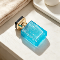 Flacon de parfum en verre bleu 50 ml, texture craquelée, corps légèrement translucide, col doré, bouchon noir, vente en gros