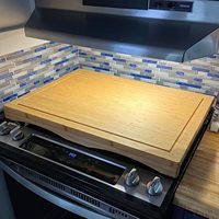 Planche à découper ronde en bois d'acacia et couvercle de cuisinière avec design durable et écoresponsable, finition brun riche, optimise l'espace de la comptoir