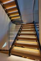 Escalier flottant moderne avec marches en bois droit, garde-corps en verre et éclairage LED