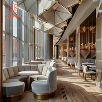 Muebles de comedor de lujo Sofás de tela beige curvo con base de metal dorado y mesas redondas de madera para restaurante