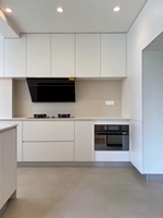Armoire de cuisine minimaliste moderne sans poignées avec tiroirs et porte à charnières en laque blanche pour salle à manger