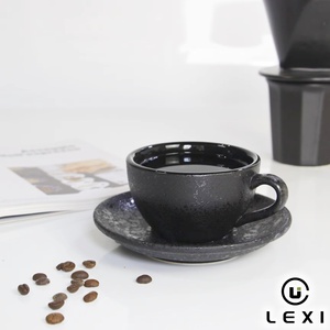 Ensemble tasse et soucoupe à café en céramique noire mate de luxe avec glaçure texturée effet lune, parfait pour la présentation d'espresso ou de latte art - Product Image 1