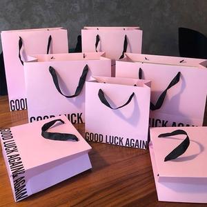 Sacs cadeaux rose pastel avec inscription « Good Luck Again » et poignées en ruban noir – Choix charmant pour sacs cadeaux en papier - Product Image 1