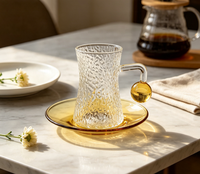 Ensemble de tasses à café en verre borosilicate martelé, forme sablier texturée, avec poignée boule ambrée, capacité 120 ml, et soucoupe à thé