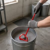 Pelle mélangeuse robuste en acier rouge avec poignée noire et tête de mélange annulaire pour la préparation et le mélange des matériaux en atelier