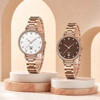 Montre à quartz de luxe moderne et personnalisée pour femme, avec verre, bracelet en acier inoxydable, lunette sertie de diamants, aiguilles en forme de feuille, date et fermoir papillon