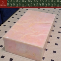 Table basse GOLDKING en onyx rose translucide avec veines rose clair et blanches pour un centre de table de luxe dans le salon, utilisation artistique