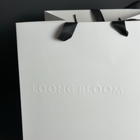 Sac en papier écologique noir mat avec logo argenté et relief floral pour boutique de cosmétiques, cadeau, parfum, vente au détail, sacs en papier personnalisés