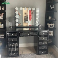 Coiffeuse noire contemporaine glamour avec grand miroir éclairé, tiroirs incrustés de cristaux et rangement organisé pour la routine de maquillage en chambre