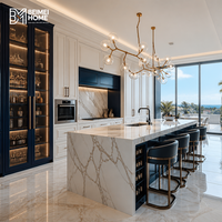 Meubles de cuisine modernes bleu marine style américain, tour à vin en verre cannelé, îlot cascade en marbre Statuario, menuiserie sur mesure pour penthouse