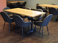 Ensemble table et chaises de restaurant moderne avec sièges rembourrés noirs et pieds en métal imitation bois pour café, bistrot, hôtel, salle à manger