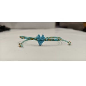 Bracelet artisanal Sstringz en perles Miyuki Delica bleu turquoise avec accents dorés, réglable, motif cœur central, amitié - Product Image 1