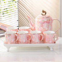 Elegante tetera de cerámica y 6 tazas de té con un mango de color dorado y una tapa con un acabado brillante iridiscente