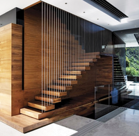 Escalier droit sur mesure de luxe, fabriqué avec des accents en nickel brossé et des marches larges, pour les lofts résidentiels haut de gamme