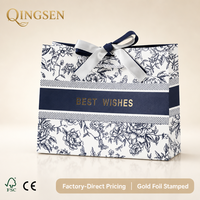 Sacs cadeaux en papier personnalisés de luxe élégants bleu marine à motifs floraux avec estampage à chaud doré, ruban en satin et nœud pour fêtes et vente au détail