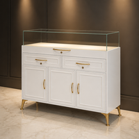 Vitrine de présentation de bijoux de luxe, laque blanche mate, quincaillerie dorée, dessus en verre trempé sans cadre, éclairage LED, tiroirs de rangement, portes