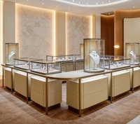 Table de présentation de bijoux incurvée avec éclairage LED |   Vitrine en verre à coins arrondis avec cadre en métal doré brossé beige |   Personnalisable