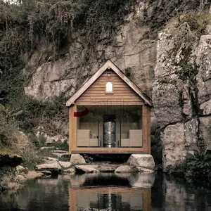 古雅的林地桑拿小屋，带玻璃正面和天然石材背景