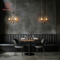 Canapé banquette moderne de luxe en cuir noir rembourré avec structure métallique et table en pierre frittée pour restaurant, café, mobilier commercial