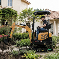 Mini-excavatrice avec fourches à palettes pour la manutention de palettes sur chantier