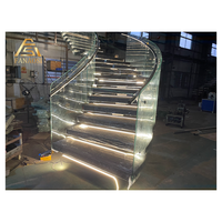 Escalier en colimaçon courbé sur mesure avec marches en acajou, balustres en fer forgé et main courante en laiton poli