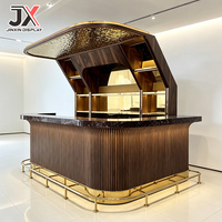 Comptoir de bar de luxe sur mesure, design incurvé, en noyer cannelé, avec dessus en marbre foncé, marchepied, capot LED, armoire, mobilier pour club et restaurant
