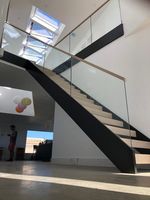Villa-Innentreppe mit Doppelwangenkonstruktion, Mattschwarzer Stahlträger, Holzstufen, Maßgefertigtes Geländer