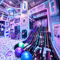 Aire de jeux intérieure sur le thème de l'espace, château gonflable, équipement de jeux doux avec lumières néon, toboggans, piscine à balles