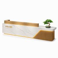 Comptoir de réception moderne de luxe personnalisé en marbre avec façade en bois rainuré LED pour bureau, hôtel, salon, spa, clinique