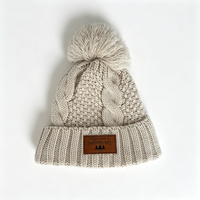 Bonnet tricoté personnalisé OEM chaud d'hiver avec pompon et logo en cuir PU, unisexe, en acrylique, avec revers, vente en gros, pour Noël