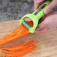 Multifunctionele handmatige plastic aardappel- en groenteschiller met roestvrijstalen mes, rood/groen, huishoudelijk gebruik.