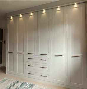 Armoire intégrée moderne blanche avec portes à panneaux et éclairage supérieur - Product Image 1