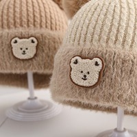 Bonnet tricoté épais et chaud pour enfant, nouveau style, motif ours mignon avec double pompon en peluche, idéal pour l'hiver froid – Fournisseur direct usine