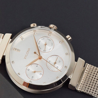 Montre pour femme avec bracelet en maille argentée, index des heures en cristal et affichage à trois aiguilles sur un cadran multifonctionnel