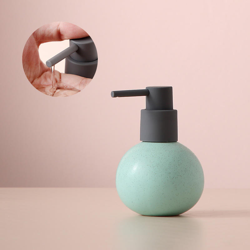 Petite boule rose-vert de lotion avec tête de pompe pointant vers le bas