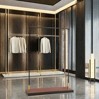 Présentoir pliable moderne et personnalisable en acier inoxydable doré brillant pour vêtements de magasin de détail, idéal pour les boutiques de prêt-à-porter féminin et les usines.