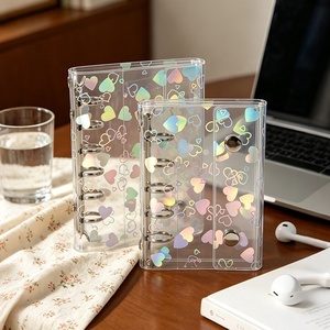 Carnet de notes A6/A7 holographique en forme de cœur, nouveau design, faible quantité minimale de commande, en PVC transparent, rechargeable à 6 anneaux, avec 2 boutons-pression et système d'enveloppes pour espèces - Product Image 1